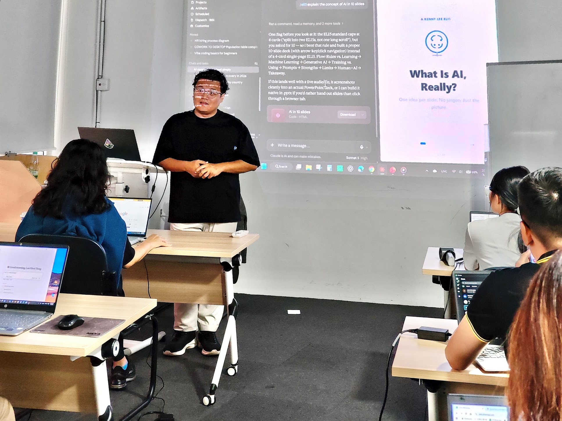 Kenny leading an AI workshop with participants using laptops